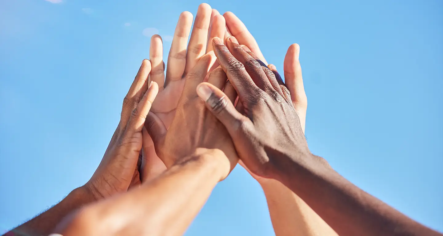 A picture of people reaching up and holding each others hands (Photo)