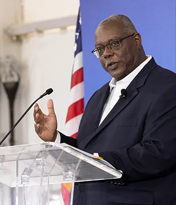 A man giving a speech behind a lectern (Photo)