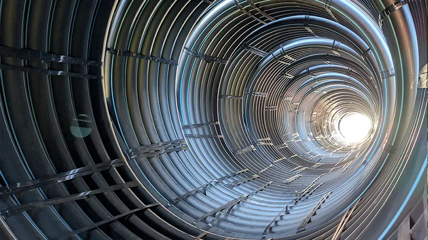 The image you provided shows a metallic structure that resembles a tunnel or a spiral tube with many reflective surfaces.