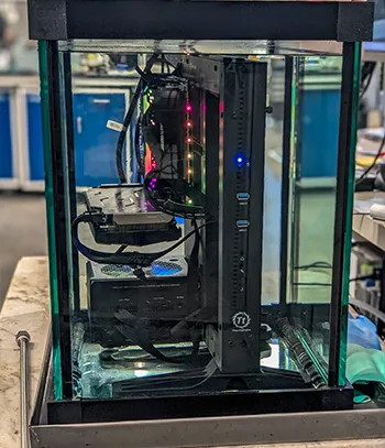 The image shows a piece of computer hardware inside an acrylic case, which has been set up to protect and display the internal components.