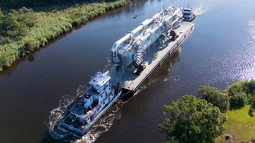 This is an image of a large industrial or processing facility. There's a sign in the foreground.