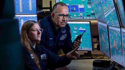 The image you've provided shows a person working at what appears to be an operations center or control room, likely for a space program given the context provided. There are various screens displaying different types of data and information, typical of such facilities where they monitor and manage space missions.