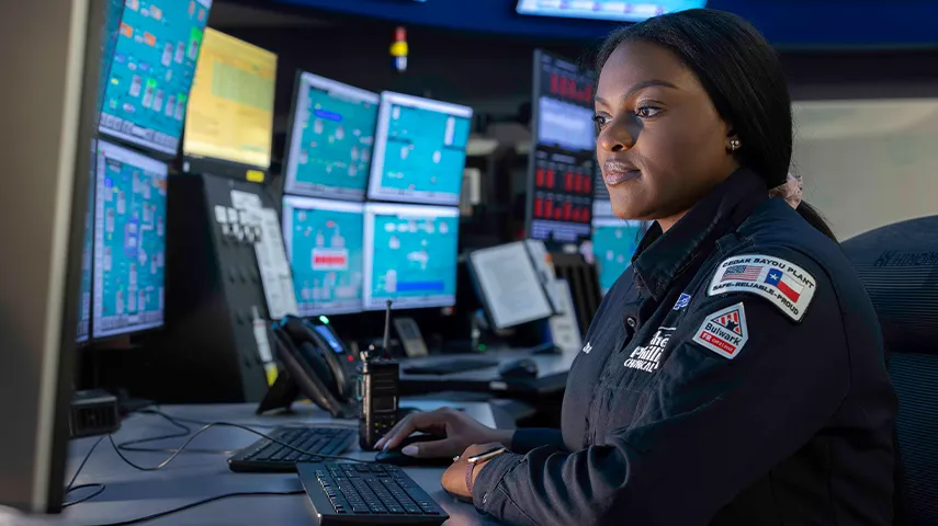 In the image, there is a person sitting in what appears to be a control station or command center.