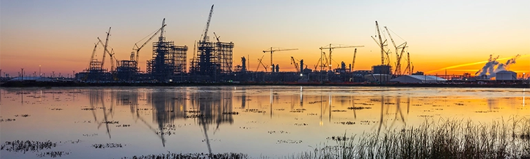 This is an image of a beautiful sunset. In the sky, the sun is setting and casting a warm glow over the scene. The colors are soft, ranging from warm yellows to soft reds as the light diminishes.