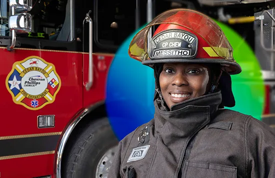 This is an image of a firefighter. The firefighter is wearing a full set of turnout gear, which includes a jacket. The person is also wearing a helmet. The background suggests the image was taken in a fire station given