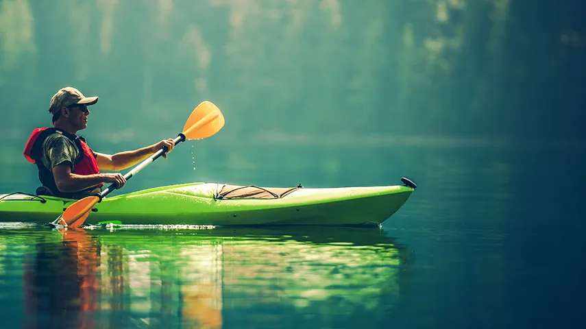 A man kayaking on a calm lake in nature (Photo)