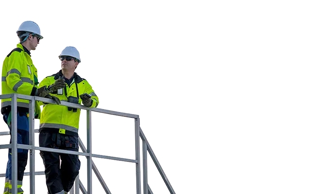 Two workers with safety jackets and hemets discussing (photo)